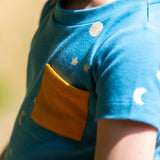 A close up of the yellow pocket on the top of the LGR Dawn Organic T-Shirt & Jogger Playset