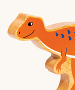 A close up of the chunky wooden Lanka Kade orange Hysilophodon dinosaur figure available at Babipur.