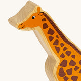 A close up of the chunky wooden Lanka Kade orange giraffe animal figure available at Babipur showing its facial features