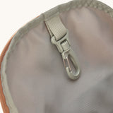 A close up of the Lassig kids mini caramel happy print backpack showing the handy clip on the inside