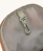 A close up of the Lassig kids mini caramel happy print backpack showing the handy clip on the inside