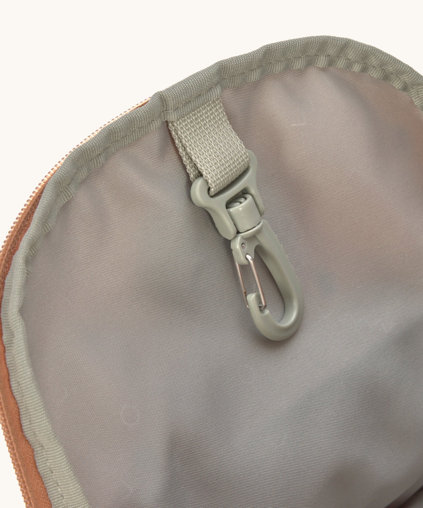 A close up of the Lassig kids mini caramel happy print backpack showing the handy clip on the inside