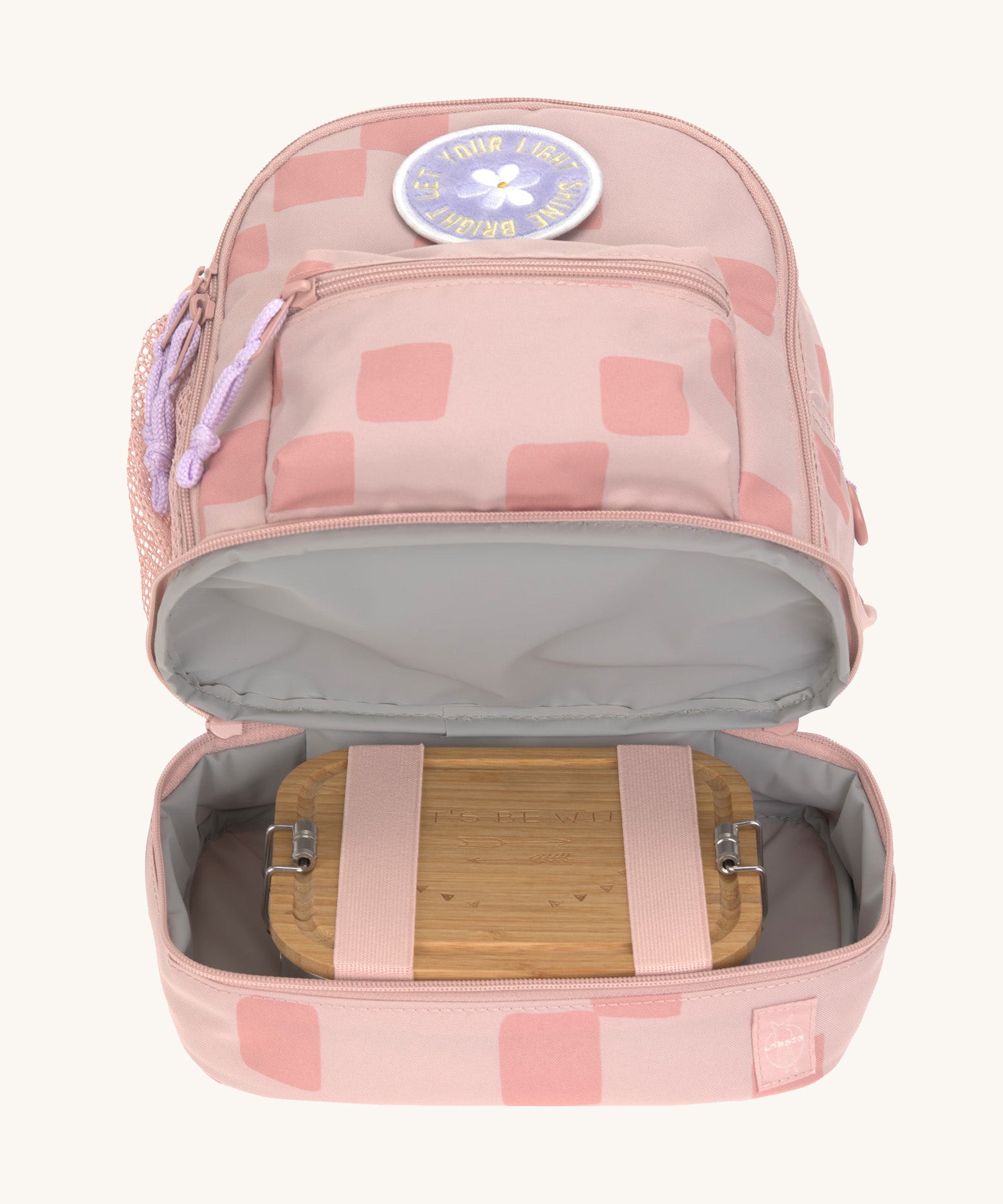 The inside of the Lassig kids mini rose pattern party backpack showing a lunchbox inside the bottom compartment.