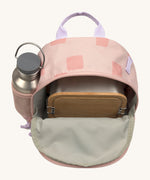 The inside of the Lassig kids mini rose pattern party backpack showing various items  inside the main compartment with a bottle in the mesh side pocket