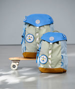 2 Lassig kids mini outdoor backpack in sunny explorer green on a mini skateboard