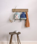 Lassig kids tiny backpack in penguin and whale available at Babipur handing on hookd with a wooden stool underneath