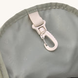 A close up of the Lassig kids mini olive happy print backpack showing the handy clip on the inside
