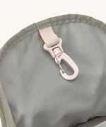 A close up of the Lassig kids mini olive happy print backpack showing the handy clip on the inside
