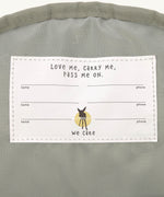 A close up of the Lassig kids mini midnight blue happy print backpack showing the white name tag detail on the inside