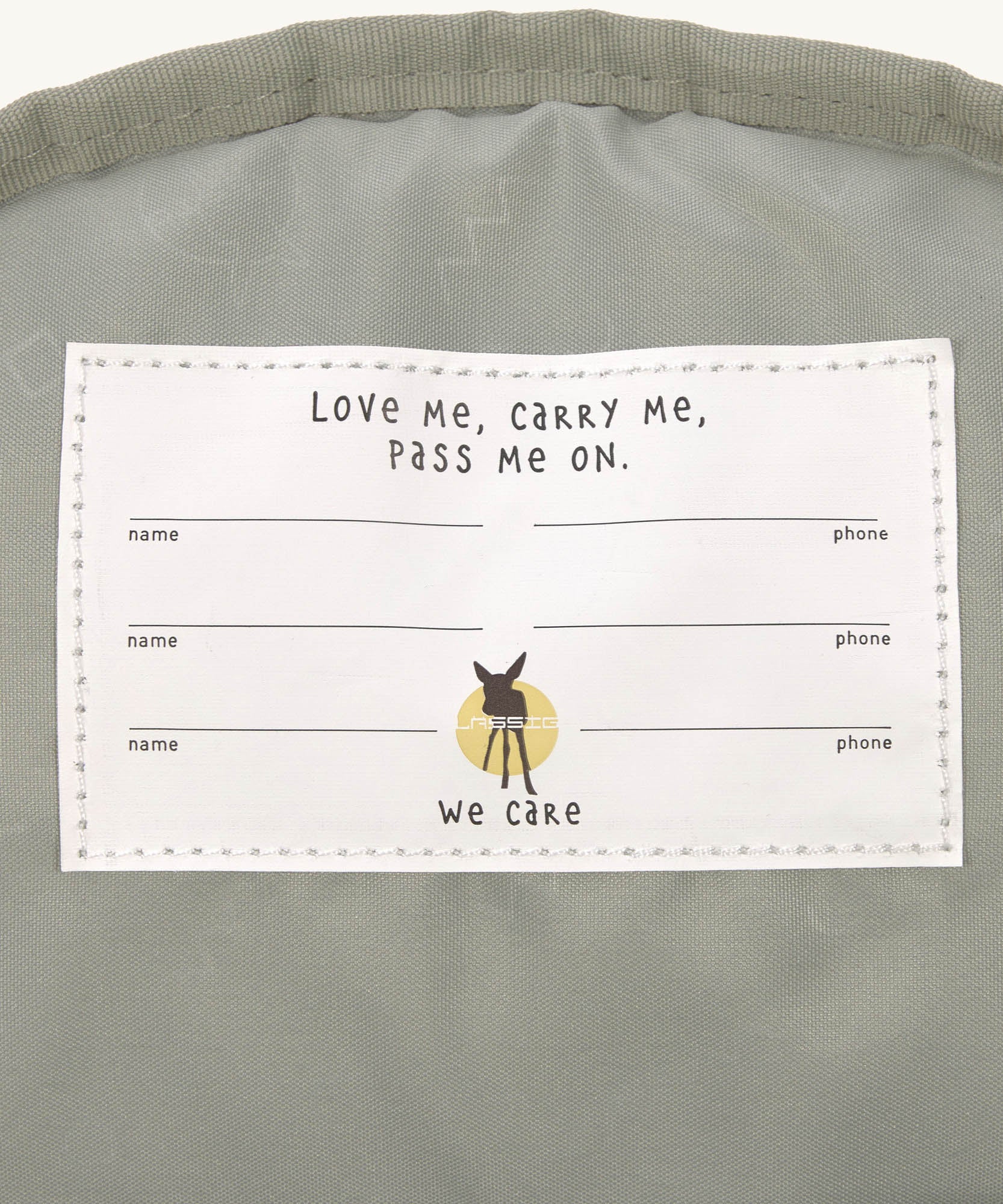 A close up of the Lassig kids mini midnight blue happy print backpack showing the white name tag detail on the inside