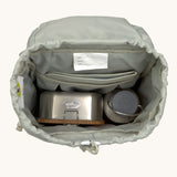 The inside of the Lassig kids mini outdoor backpack in sunny explorer pink showing the room inside the main compartment. Features a blue toggle for closing the compartment