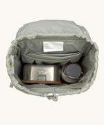 The inside of the Lassig kids mini outdoor backpack in sunny explorer pink showing the room inside the main compartment. Features a blue toggle for closing the compartment