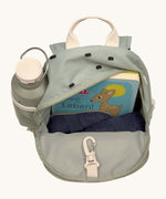 The inside of the Lassig kids mini olive happy print backpack showing various items  inside the main compartment with a bottle in the mesh side pocket