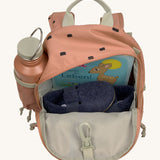 The inside of the Lassig kids mini caramel happy print backpack showing various items  inside the main compartment with a bottle in the mesh side pocket