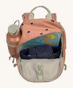 The inside of the Lassig kids mini caramel happy print backpack showing various items  inside the main compartment with a bottle in the mesh side pocket