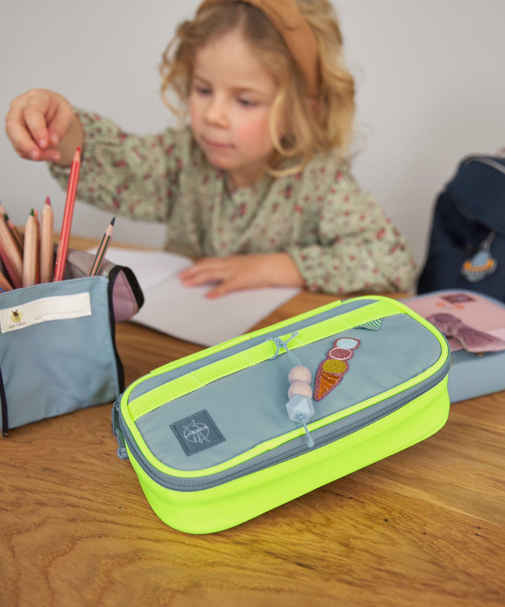 Lassig spacy school pencil case in neon yellow with a funky decorative patche and hanging wooden tag.