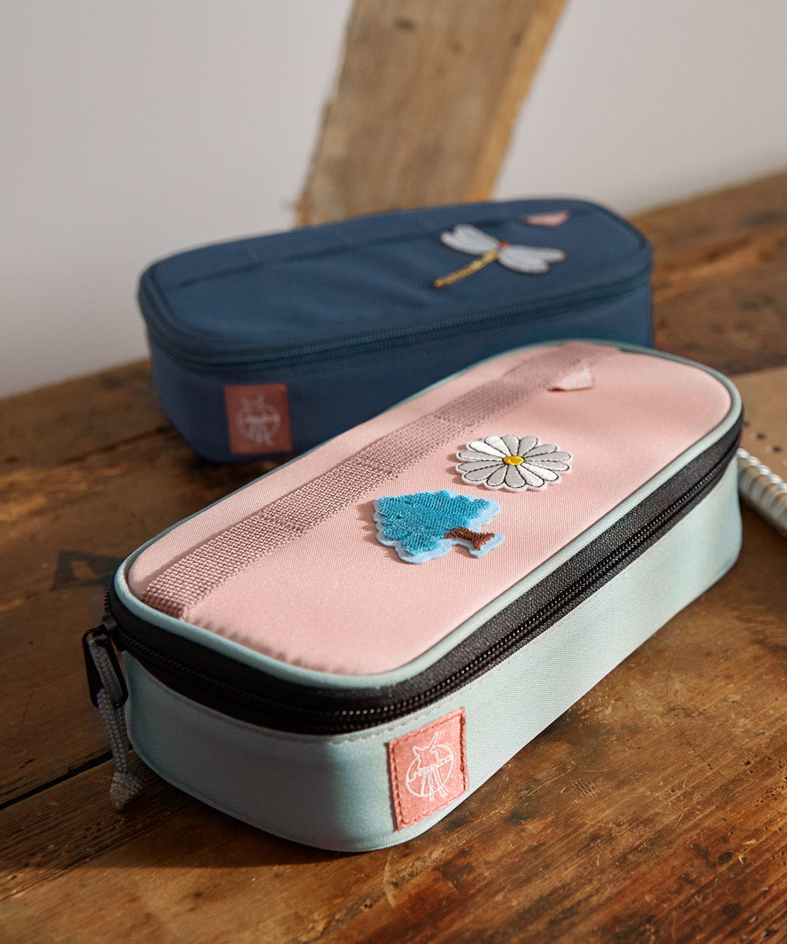 A close up of the Lassig spacy school pencil case in navy and pink showing the black zip detail