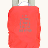A neon pink backpack cover for the Lassig kids mini outdoor backpack with a slogan saying 'stay outside and explore the world'