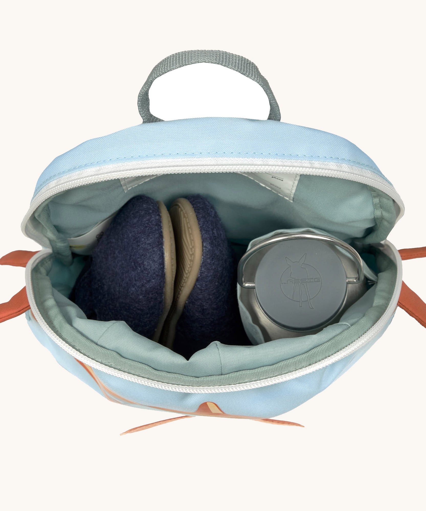 A close up of the Lassig kids tiny aeroplane backpack showing the bottle holder detail and space inside the main compartment of the backpack