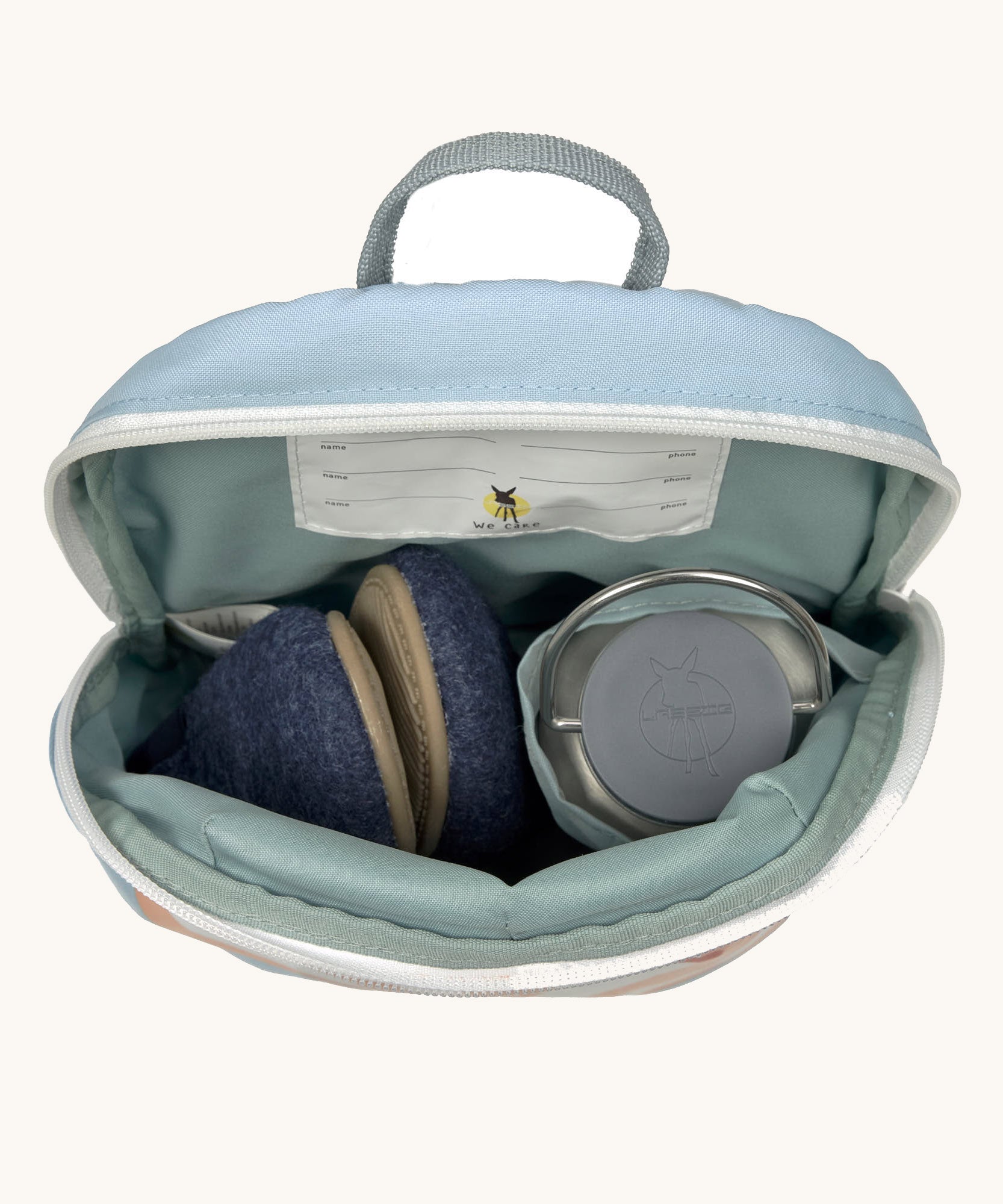 A close up of the Lassig kids tiny balloon backpack showing the bottle holder detail and space inside the main compartment of the backpack