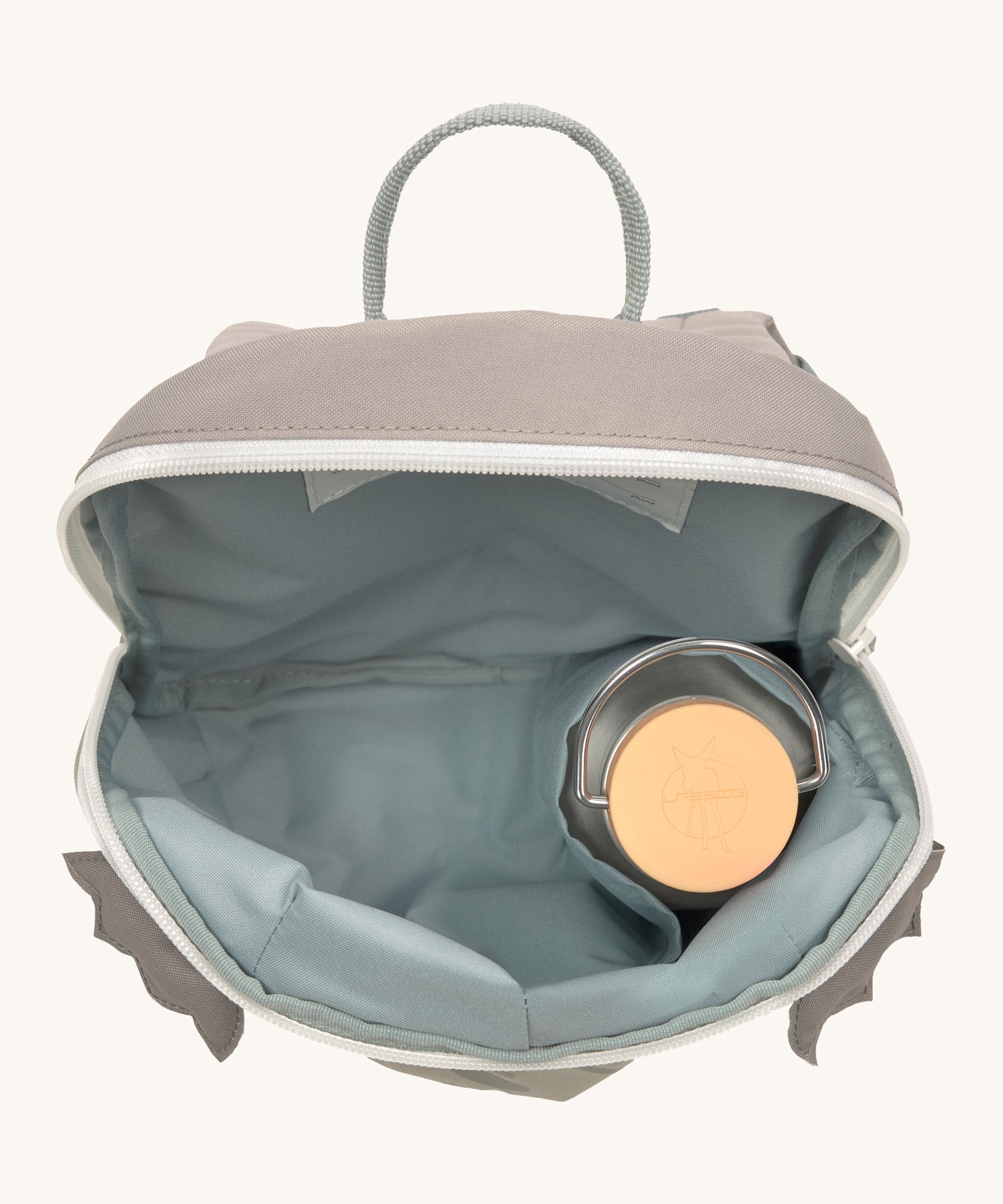 A close up of the Lassig kids tiny dragon backpack showing the bottle holder detail inside the backpack