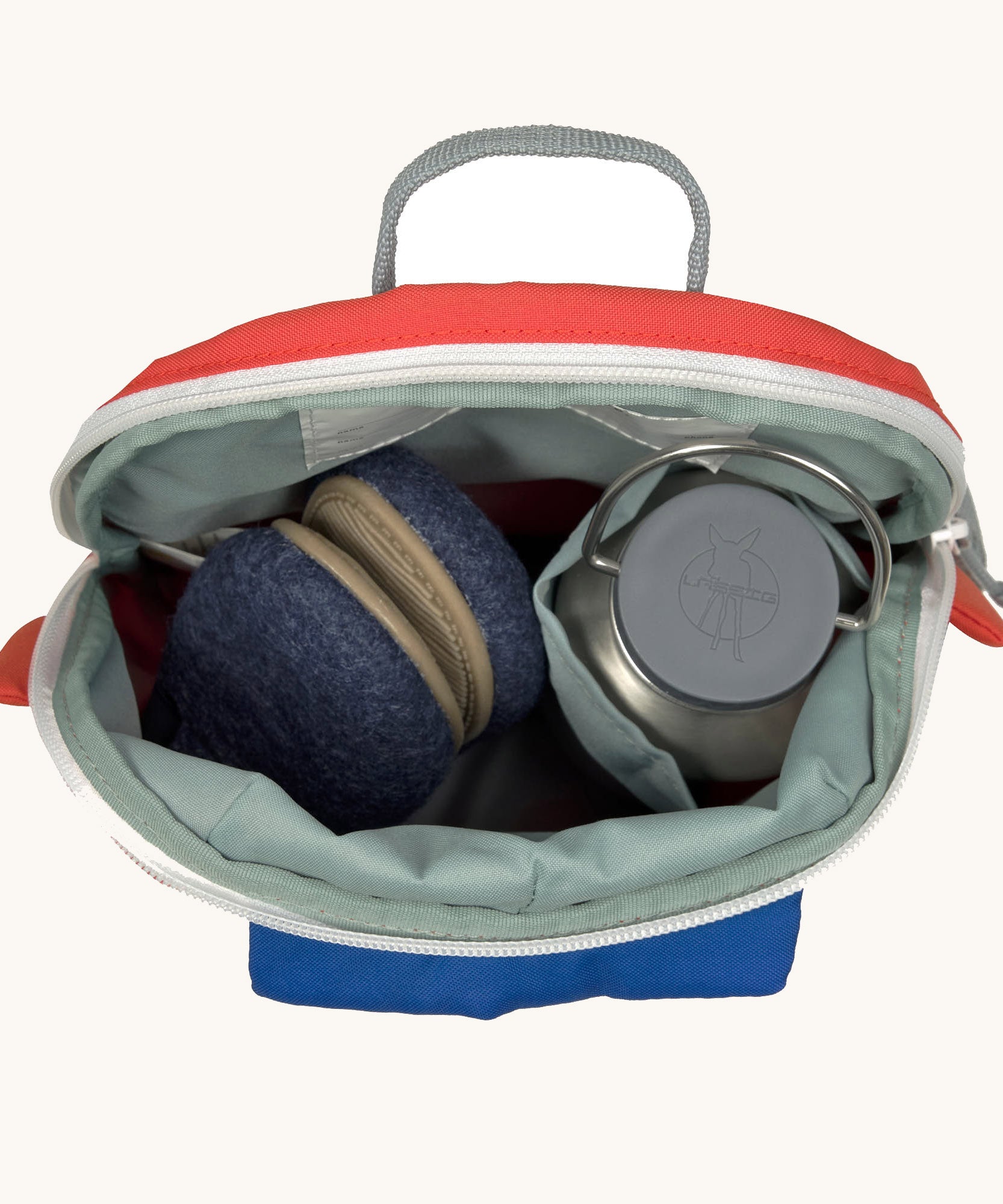 A close up of the Lassig kids tiny fire engine backpack showing the bottle holder detail and space inside the main compartment of the backpack