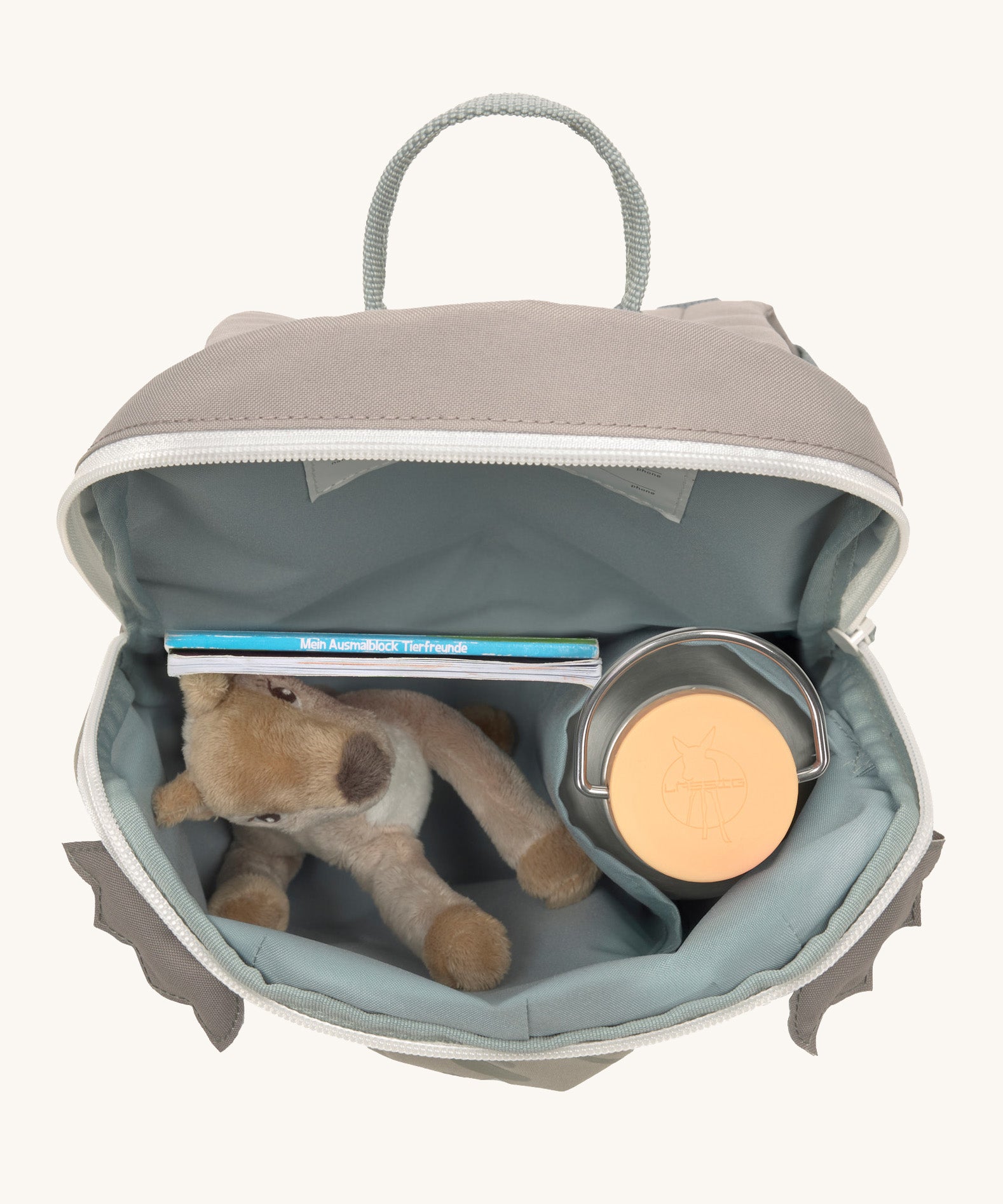 A close up of the Lassig kids tiny dragon backpack showing the bottle holder detail and space inside the main compartment of the backpack