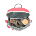 Lassig Kids Tiny Backpack in a bright coral colour with a dinosaur face, shown from a top angle to show the inside space. Inside is a water bottle, some books, and a soft cuddly toy.