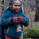 Child in a forest wearing Knitted Mittens in Brown with red flowers by Little Green Radicals - made from warm GOTS organic and Fairtrade certified cotton - available now at Babipur.