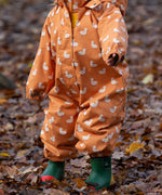 Baby playing in a forest wearing a Waterproof Winter Suit in Gold Ducks print, by Little Green Radicals, made from recycled bottles and a cosy polyester fleece, buy now at Babipur.