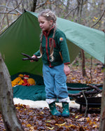 Girl camping in a forest wearing Little Green Radicals Kids Polar Fleece Jacket in Olive green with a red pocket and zip, buy now at Babipur.
