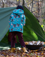 Back of girl stood in a forest wearing a Kids Warm Waterproof, 5000MM rating, Winter Hooded School Coat in Winter Rabbits print, by Little Green Radicals, made from recycled bottles and a cosy polyester fleece, buy now at Babipur.