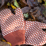 Close up of a pair of Little Green Radicals Knitted Mittens with a Ginger Orange and Cream Diamond Pattern - made from soft Fairtrade certified and GOTS organic cotton - with thick orange cuffs - available to buy at Babipur.
