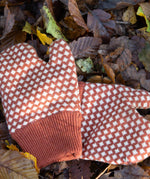 Close up of a pair of Little Green Radicals Knitted Mittens with a Ginger Orange and Cream Diamond Pattern - made from soft Fairtrade certified and GOTS organic cotton - with thick orange cuffs - available to buy at Babipur.