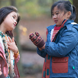 Child playing in a forest wearing a Long Sleeve Orange Ginger Knit Mittens by Little Green Radicals - made from soft GOTS organic and Fairtrade certified cotton - brown with red flowers, available to buy at Babipur.