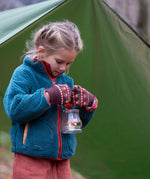Child in a forest wearing Little Green Radicals Knitted Mittens in Brown Collecting Flowers - made from warm GOTS organic and Fairtrade certified cotton - shop at Babipur.