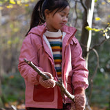 Child in a forest wearing Little Green Radicals Knitted Collar Mitten  in Ginger Diamons - made from warm GOTS organic and Fairtrade certified cotton - shop at Babipur.