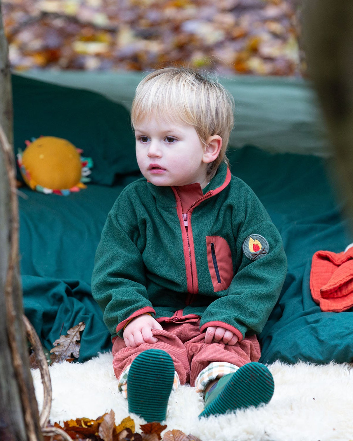 Child camping in a forest wearing Little Green Radicals Kids Polar Fleece Jacket in Olive - made from recycled polar fleece - available to buy at Babipur.