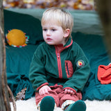 Child camping in a forest wearing Little Green Radicals Kids Polar Fleece Jacket in Olive - made from recycled polar fleece - available to buy at Babipur.
