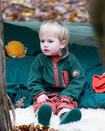 Child camping in a forest wearing Little Green Radicals Kids Polar Fleece Jacket in Olive - made from recycled polar fleece - available to buy at Babipur.