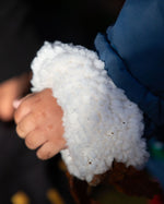 Close up of child's hands, wearing Little Green Radicals Waterproof Winter School Coat, with a cozy recycled polyester lining, made from recycled bottles, with a Moonlight Blue print, PFC Free, for sale at Babipur.