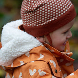 Close up of a child outdoor wearing a Kids Warm Waterproof, 5000MM rating, Winter Hooded School Coat in gold duck print, with a fluffy hood, by Little Green Radicals, made from recycled bottles and a cosy polyester fleece, buy now at Babipur.