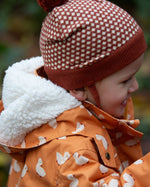Close up of a child outdoor wearing a Kids Warm Waterproof, 5000MM rating, Winter Hooded School Coat in gold duck print, with a fluffy hood, by Little Green Radicals, made from recycled bottles and a cosy polyester fleece, buy now at Babipur.