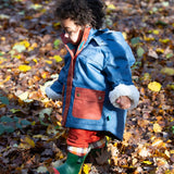 Baby in a forest wearing a Little Green Radicals PFC Free Waterproof Winter Coat with a cosy fleece hood, made from recycled bottles and a cosy polyester fleece, in a Moonlight Blue print, available now at Babipur.