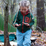 Girl walking in a forest wearing Little Green Radicals Kids Polar Fleece Jacket in Olive green - made from recycled polar fleece - for sale at Babipur.