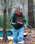 Girl walking in a forest wearing Little Green Radicals Kids Polar Fleece Jacket in Olive green - made from recycled polar fleece - for sale at Babipur.