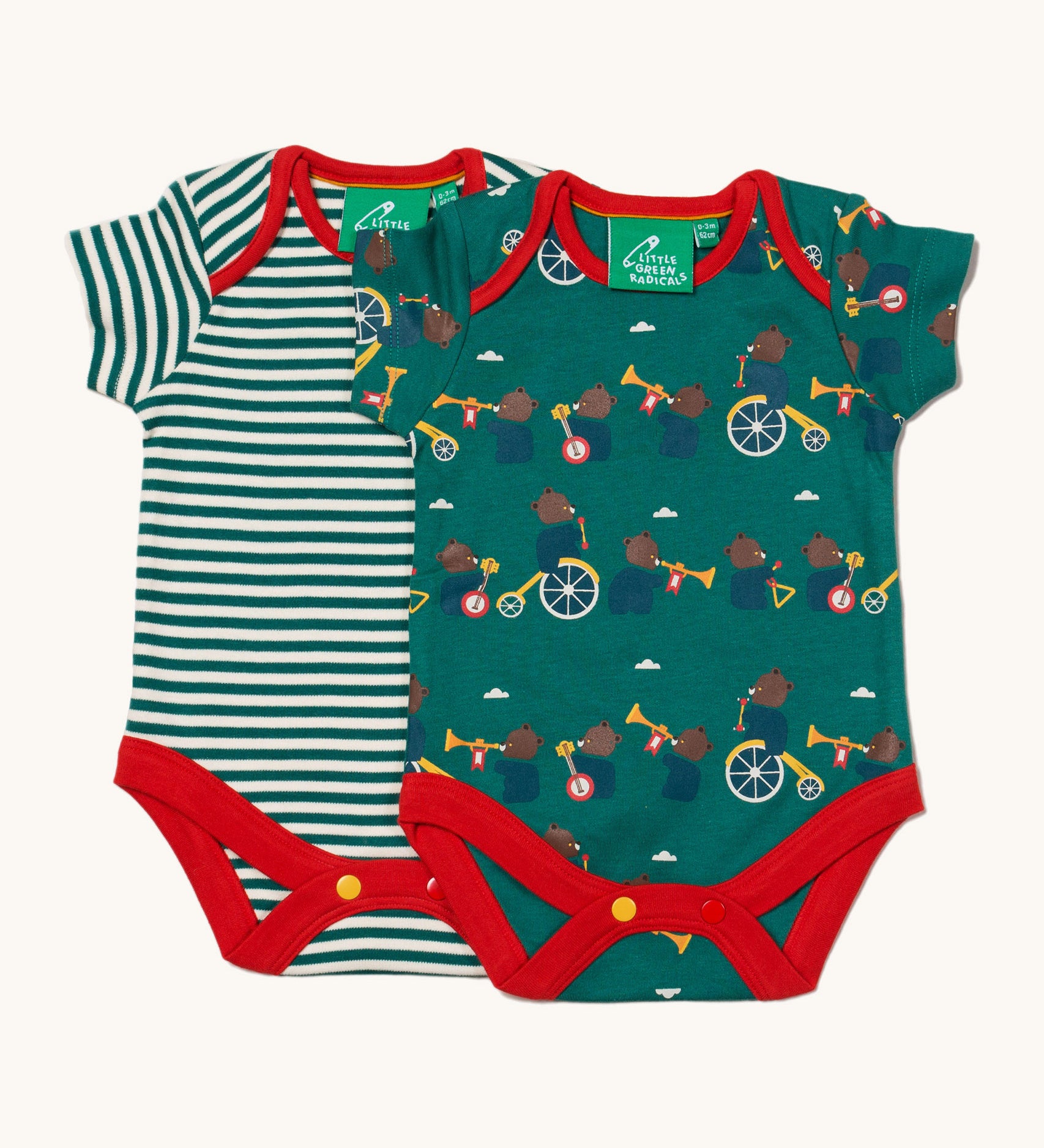 A 2 pack of Little Green Radicals The Bear Jamboree Baby Body Set. One vest has a green and white stripe with the other vest featuring an all over  print of bears playing instruments. These short sleeved baby best are part of a wide range of organic cotton baby clothes available at Babipur.