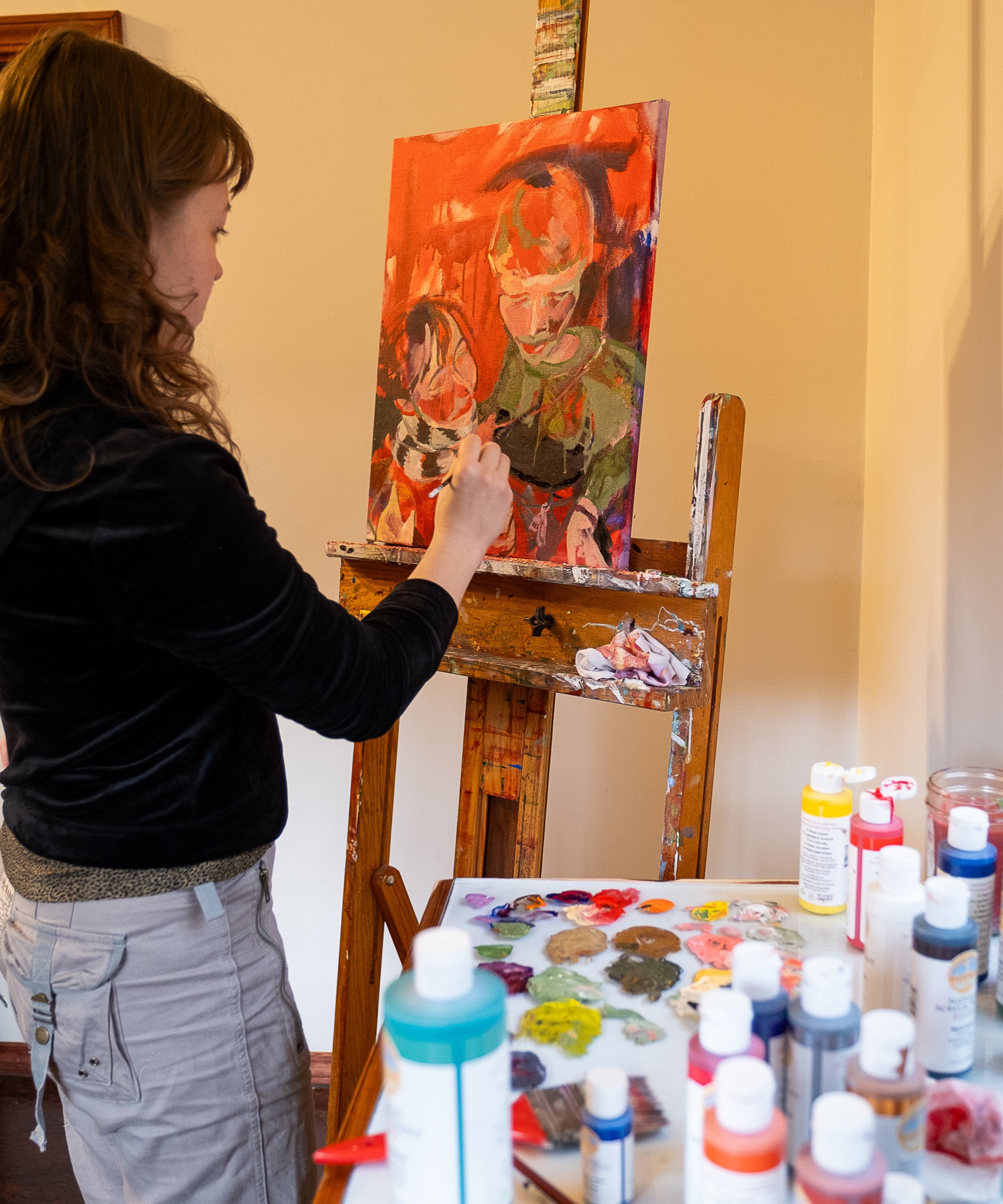 An artist using the Natural Earth Paint acrylic paint on a canvas