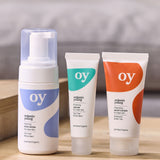The Green People OY Skincare set of face wash, serum and moisturiser, set on a wooden table
