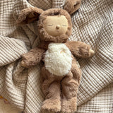 A Olli Ella cozy dinkum dog Digby doll lying on a blanket showing it's cute floppy ears and sleeping face. This soft toy doll is available at Babipur.